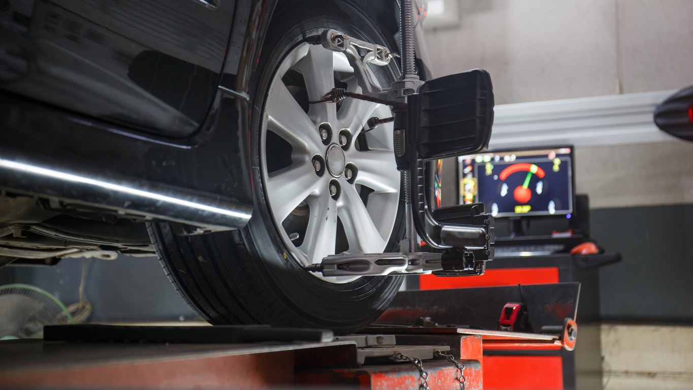 Car-on-stand-with-sensors-on-wheels-for-wheels-alignment-camber-check-in-workshop-of-Service-station